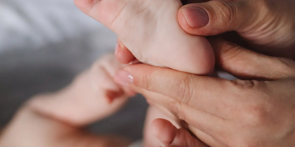 Massage des pieds d'un bébé par son parent